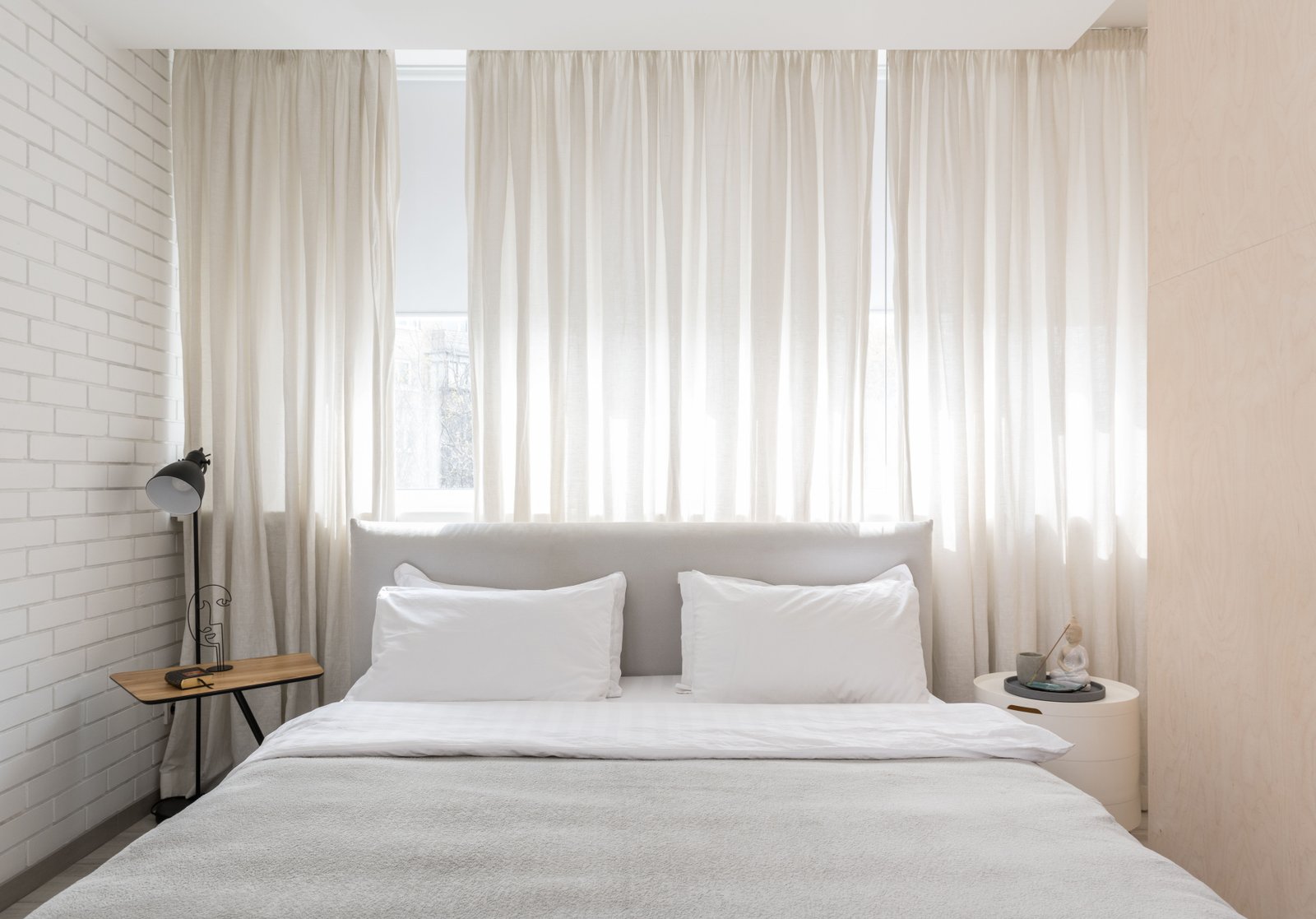 Tende arricciate chiare installate in una camera da letto luminosa